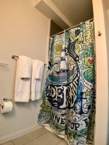 a bathroom with a shower curtain with a bottle at Modern Capitol Hill Studio Steps to Volunteer Park in Seattle