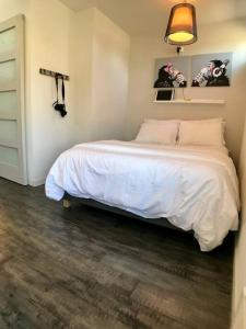 a bedroom with a bed with white sheets and a lamp at Modern Capitol Hill Studio Steps to Volunteer Park in Seattle