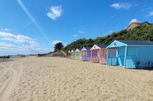 a row of colourful beach huts on a beach at The Retreat in Holland-on-Sea