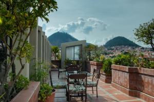 a balcony with chairs and tables and a view of a city at Glorieta Hotel in Sucre