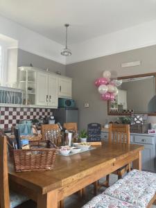 a kitchen with a wooden table with baskets and balloons at Brecart lodge Moneyglass in Toome