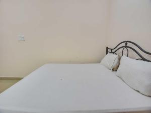 a white bed with two white pillows on it at OYO Flagship 81094 Bay Breeze Hotel in Baga