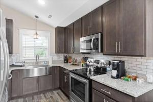 una cocina con armarios de madera y un aparato de acero inoxidable en Luxury Historic Condo 3 Mins From Downtown Commons, en Clarksville