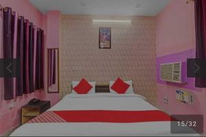 1 dormitorio con 1 cama grande con almohadas rojas en OYO 81043 Siva Guest House, en Lucknow