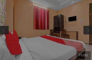 1 dormitorio con 1 cama grande con almohadas rojas en OYO 81043 Siva Guest House, en Lucknow