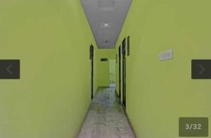 un pasillo vacío con paredes verdes y techo en OYO 81043 Siva Guest House, en Lucknow