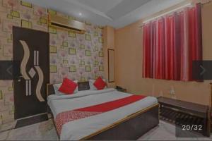 Un dormitorio con una cama con almohadas rojas. en OYO 81043 Siva Guest House, en Lucknow