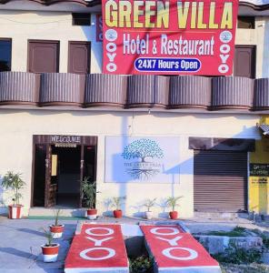 a hotel and restaurant sign on the side of a building at OYO Green Villa in Meerut