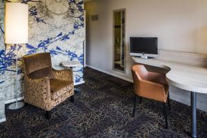 een hotelkamer met een bureau, een stoel en een tv bij Fletcher Hotel-Restaurant De Broeierd-Enschede in Enschede