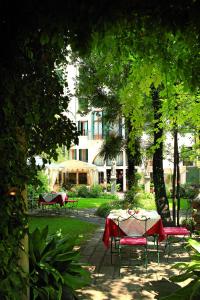 uma mesa e cadeiras num parque com um edifício em Hotel Palazzo Abadessa em Veneza