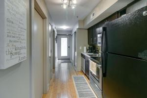 a kitchen with a black refrigerator and a wooden floor at The Lofts of Downtown (540 N 2nd St, #106) in Clarksville +8 photos