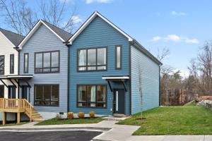 a blue house with black windows at Upscale Downtown Condo W Outdoor Patio And Parking in Clarksville