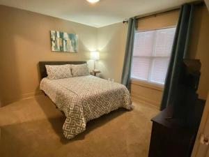 Habitación pequeña con cama y ventana en Lofts 206 - Cute And Cozy 1 Bedroom Loft en Clarksville