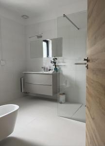 a white bathroom with a sink and a shower at Dom nad Stryszawką z SAUNĄ - domek wypoczynkowy in Stryszawa