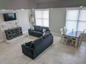 a living room with a couch and a table and a tv at The Magnolia Suite At Hilltop Acres - Clarksville in Clarksville