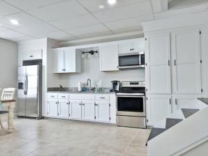 uma cozinha com armários brancos e electrodomésticos de aço inoxidável em The Magnolia Suite At Hilltop Acres - Clarksville em Clarksville