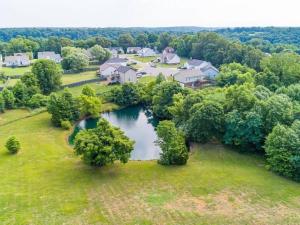 an aerial view of a house with a pond in a yard at The Magnolia Suite At Hilltop Acres - Clarksville in Clarksville