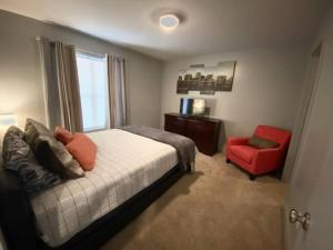 a bedroom with a bed and a red chair at The Lofts of Downtown (540 N 2nd St, #208) in Clarksville