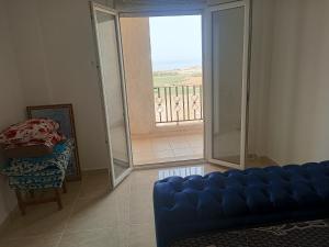 a living room with a blue couch and a balcony at F4 lpp Mostaganem Algérie in Mostaganem