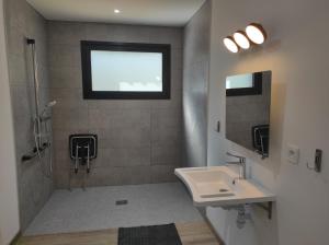 uma casa de banho com um lavatório, um chuveiro e uma janela. em Studio Lacanau Moutchic Inn PMR em Lacanau