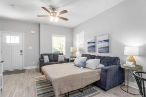 sala de estar con sofá azul y ventilador de techo en Modern Condo Close To Downtown Clarksville en Clarksville