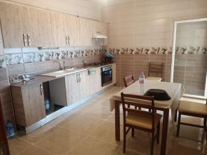eine Küche mit Tisch und Stühlen in einem Zimmer in der Unterkunft F4 lpp Mostaganem Algérie in Mostaganem