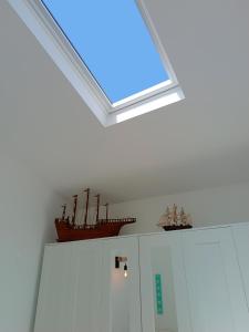 a skylight in a room with two ships on top of cabinets at Ferragood House - Historic Center in Ferragudo +22 photos