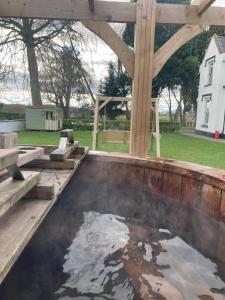 a pool of water in a patio with a wooden structure at Brecart lodge Moneyglass in Toome