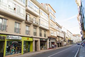 una strada di città con edifici alti su una strada di Bonito y luminoso apartamento en Rosalía de Castro a Santiago de Compostela