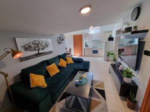 a living room with a green couch and a table at Sunset View Biograd in Biograd na Moru
