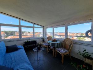 a living room with a table and chairs and windows at Sunset View Biograd in Biograd na Moru +14 photos