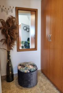 a room with a mirror and a stool and a vase at Sunset View Biograd in Biograd na Moru