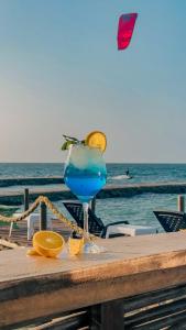 a blue drink sitting on a table next to the ocean at Múcura Club Hotel in Isla Mucura