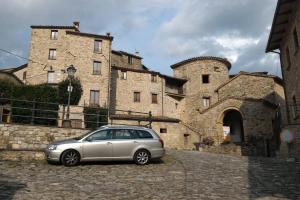 a silver car parked in front of a castle at Casa in Borgo Medievale in Toscana in Monterone