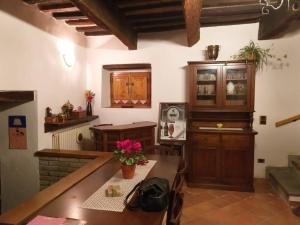 a kitchen with a table and a wooden cabinet at Casa in Borgo Medievale in Toscana in Monterone