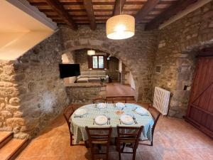 a dining room with a table in a stone building at Can Calau de Centenys in Esponellá