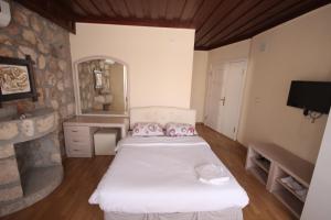 a bedroom with two beds and a stone wall at Munchen Pension in Antalya