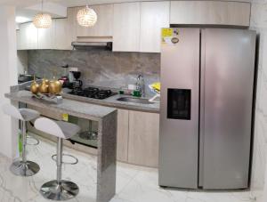 um frigorífico de aço inoxidável numa cozinha com um balcão em SU APARTAMENTO NEIVA CON AIRE Acondicionado em Neiva