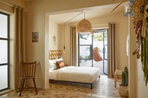een slaapkamer met een bed en een stoel bij DUNA by DW in San Juan