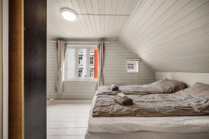 sypialnia z 2 łóżkami i oknem w obiekcie Dinbnb Homes I 4-Bedroom Historical House in Romantic Surroundings w Bergen