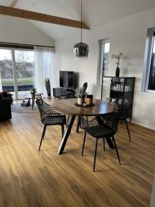 uma sala de estar com uma mesa de madeira e cadeiras em Ferienhaus mit Zugang zum Wasser em Anjum