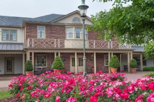 une maison avec des fleurs roses devant elle dans l'établissement Williamsburg Lodge, Autograph Collection, à Williamsburg
