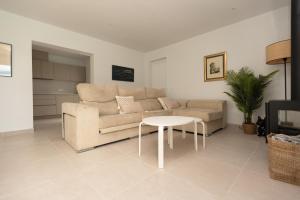 ein Wohnzimmer mit einem Sofa und einem Tisch in der Unterkunft Villa Alemania Chalet Independiente con Piscina en Urbanización Roche Conil Cádiz Andalucía España in Roche