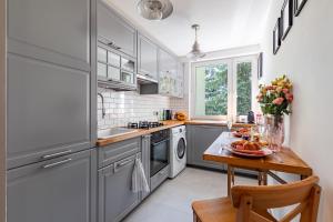 a kitchen with gray cabinets and a table with fruit on it at Secret Garden Apartment in Warsaw