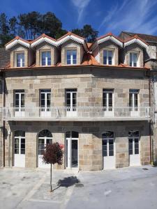 a large stone building with a balcony on top of it at Reginita Apartamentos in Arbo