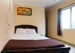 a bedroom with a bed and a window at Collection O Hotel New Royal Plaza Nampally in Hyderabad