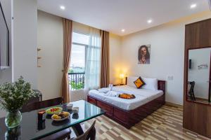 une chambre d'hôtel avec un lit et une table à manger dans l'établissement Le House Hotel and Studio, à Đà Nẵng