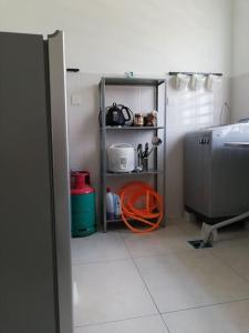 a kitchen with an orange hose on a shelf at #Guest House near Hub Education University Pagoh in Muar