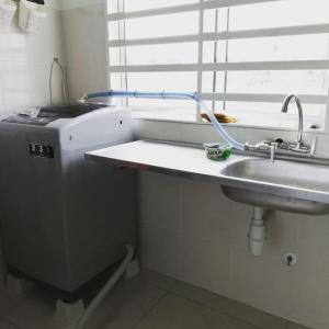 a washing machine and a sink in a bathroom at #Guest House near Hub Education University Pagoh in Muar