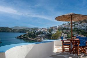 a table and chairs with an umbrella and water at Leros Windmills in Panteli